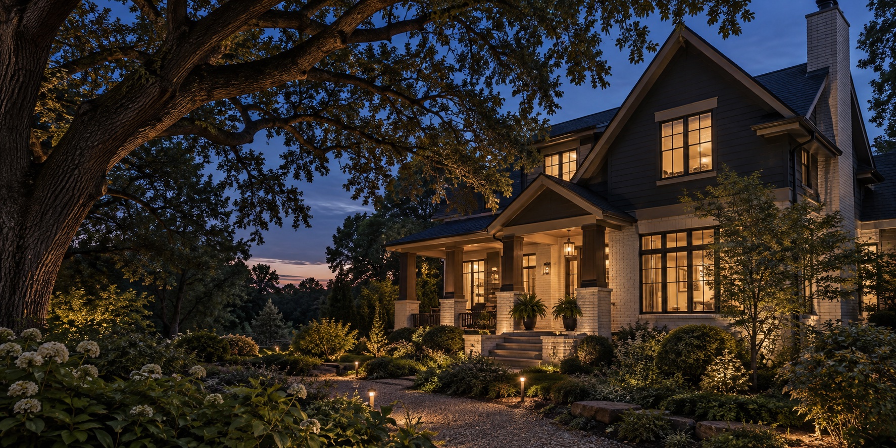 Architectural concept of a warmly lit craftsman home beneath a mature oak at dusk